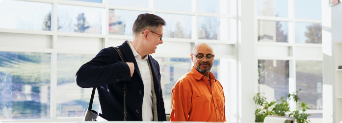 Two men walking while in conversation