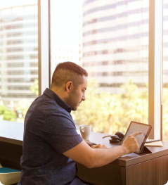 A man working on tablet device while sitting at a desk