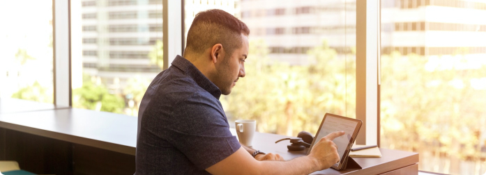 A man working on tablet device while sitting at a desk