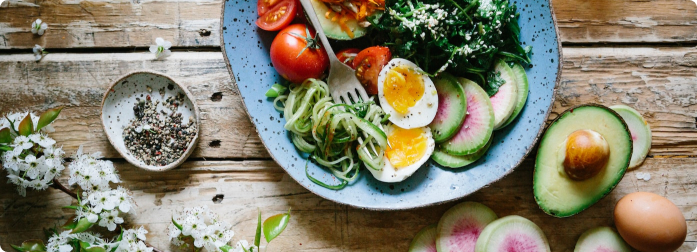 A delicous looking salad with avacodo, cucumbers, tomato and mixed greens