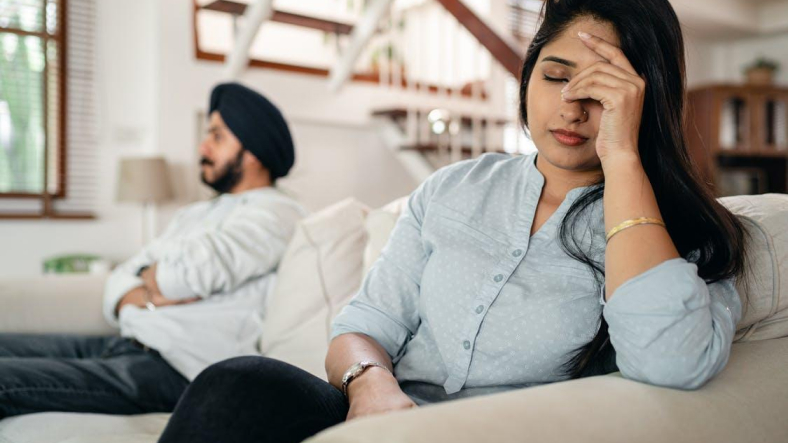 person sitting on a couch experiencing pain